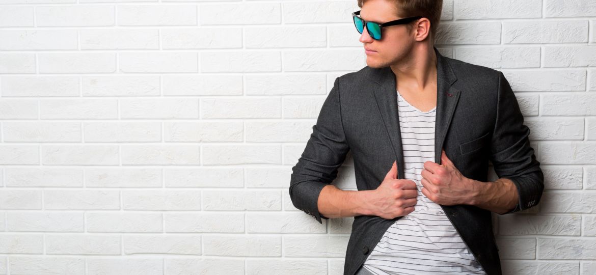 portrait-smiling-stylish-man-sunglasses-standing-against-brick-wall-modern-office